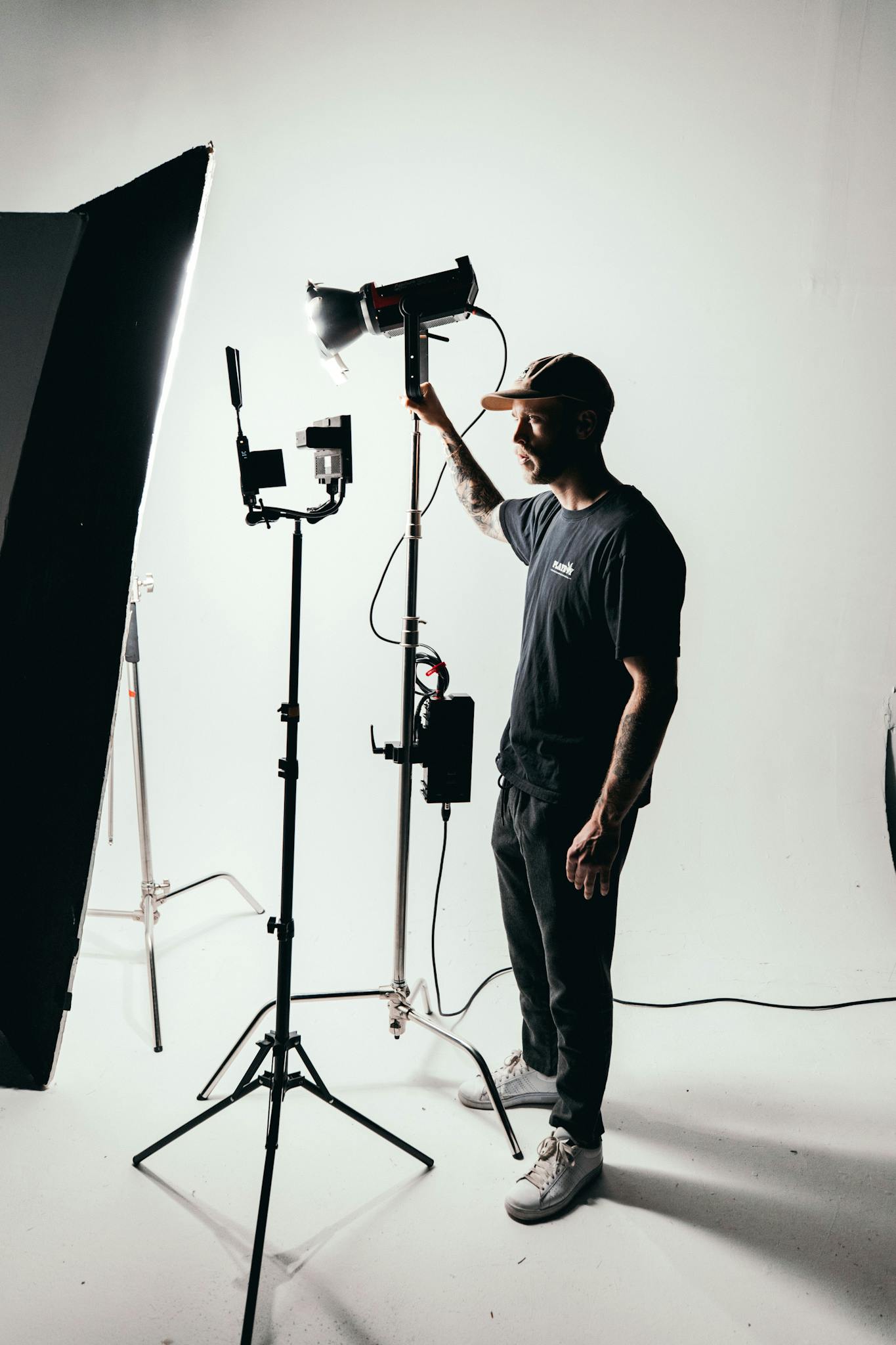 Man in White Crew Neck T-shirt Standing Near Black Microphone